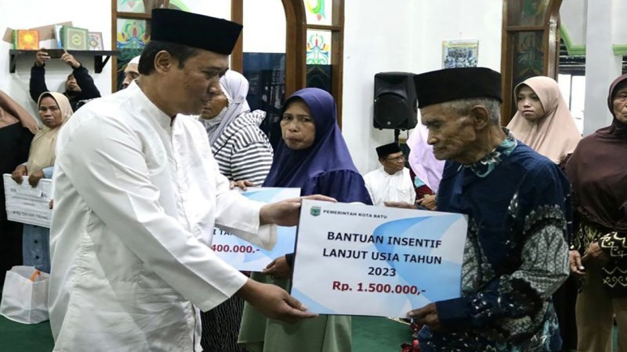 Sektretaris Daerah Kota Batu Zadim Efisiensi (kiri) pada saat menyerahkan secara simbolis bantuan insentif untuk warga lanjut usia dalam rangkaian program Safari Ramadhan, di Kota Batu, Jawa Timur. (ANTARA/HO-Humas Pemkot Batu)