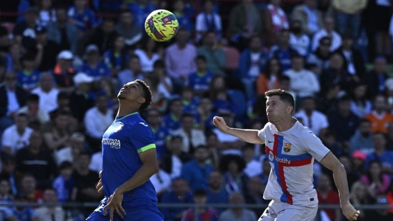 Penyerang Barcelona Robert Lewandowski (kanan) dan bek Getafe Gaston Alvarez berduel memperebutkan bola dalam pertandingan Liga Spanyol di Alfonso Perez stadium pada 16 April 2023. ANTARA/AFP/OSCAR DEL POZO
