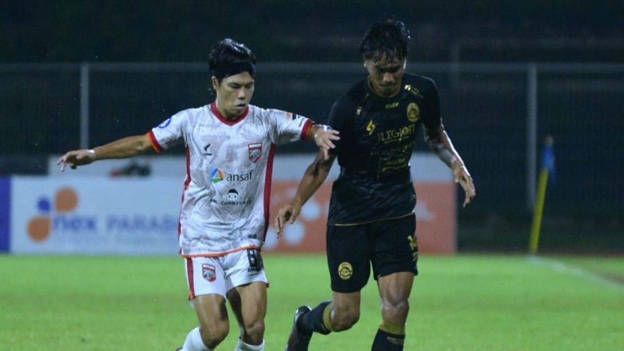 Ilustrasi - Pesepak bola Arema FC Jayus Hariono (kanan) berebut bola dengan pesepak bola Borneo FC Kei Hirose (kiri) saat pertandingan Liga 1 di Stadion I Gusti Ngurah Rai, Denpasar, Bali, Minggu (20/3/2022). ANTARA FOTO/Fikri Yusuf/foc. (ANTARA FOTO/FIKRI YUSUF)