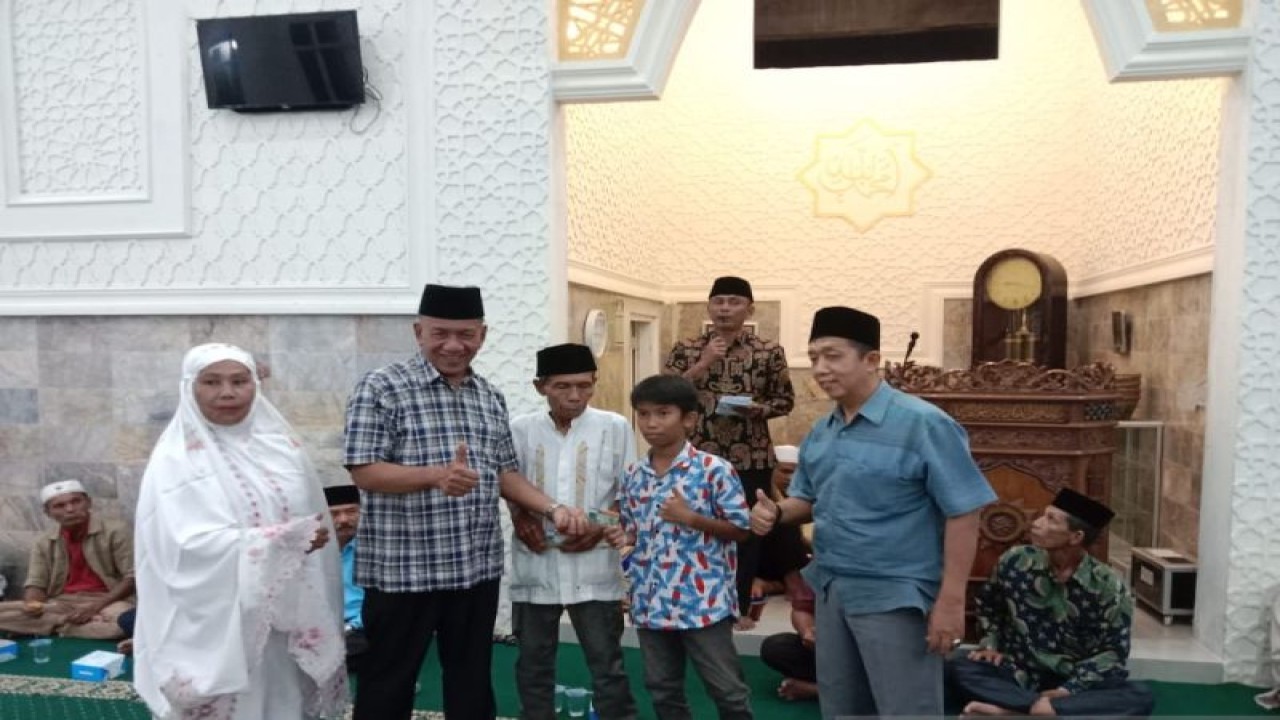 Bupati Pesisir Selatan Rusma Yul Anwar menyerahkan kartu kepesertaan BPJS Kesehatan pada masyarakat. (ANTARA/Teddy Setiaw