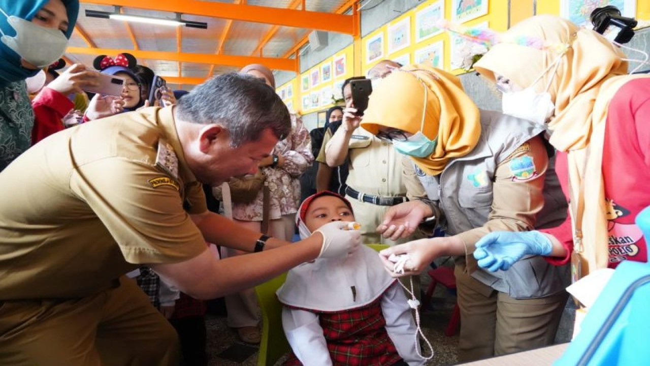 Bupati Garut Rudy Gunawan memberikan imunisasi polio kepada anak di Garut Islamic Prima Insani School, Jalan Raya Ciledug, Garut Kota, Kabupaten Garut, Jawa Barat, Senin (3/4/2023). (ANTARA/HO-Diskominfo Garut)