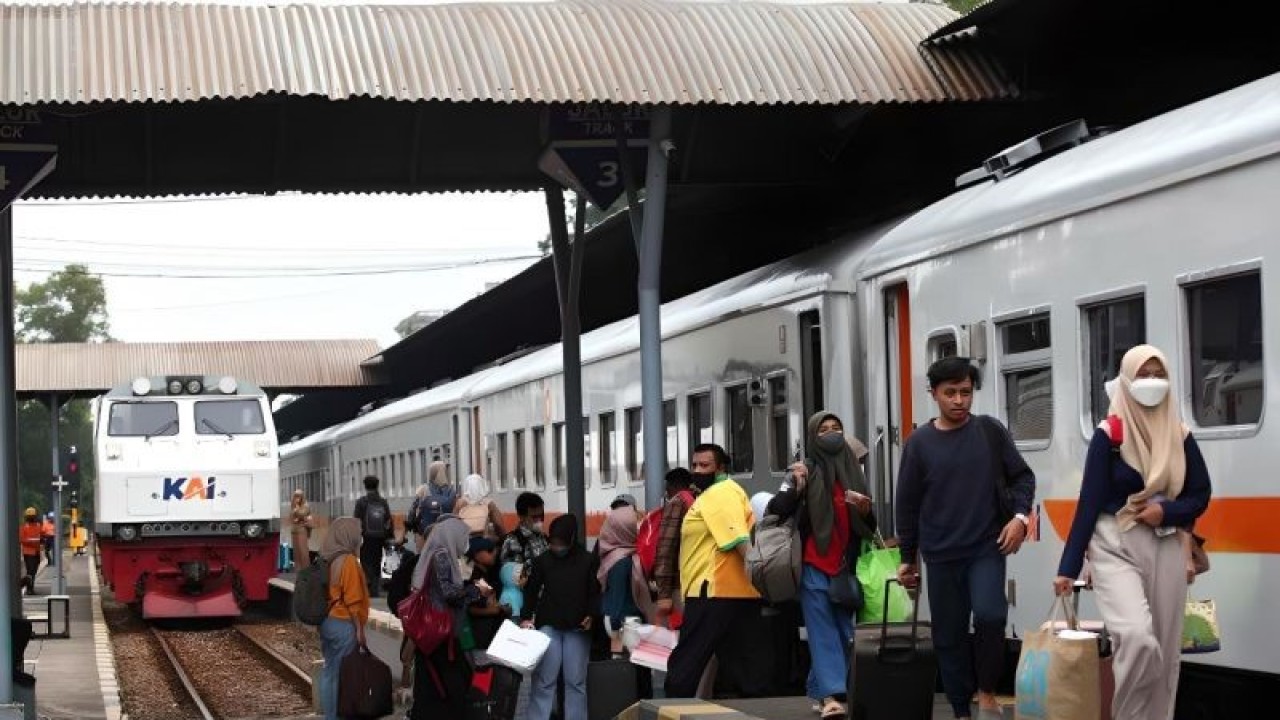 Penumpang berjalan di samping gerbong kereta api di Stasiun Surabaya Gubeng, Surabaya, Jawa Timur, Sabtu (15/4/2023). (ANTARA FOTO/Didik Suhartono/aww)