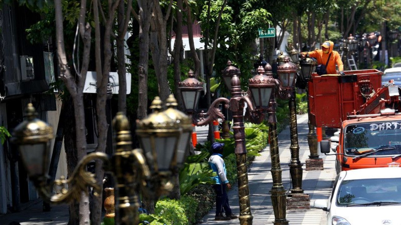Foto Arsip-Petugas Dinas Lingkungan Hidup Kota Surabaya saat menambah ornamen lampu di sepanjang Jalan Tunjungan, Kota Surabaya. (ANTARA/HO-Diskominfo Surabaya)