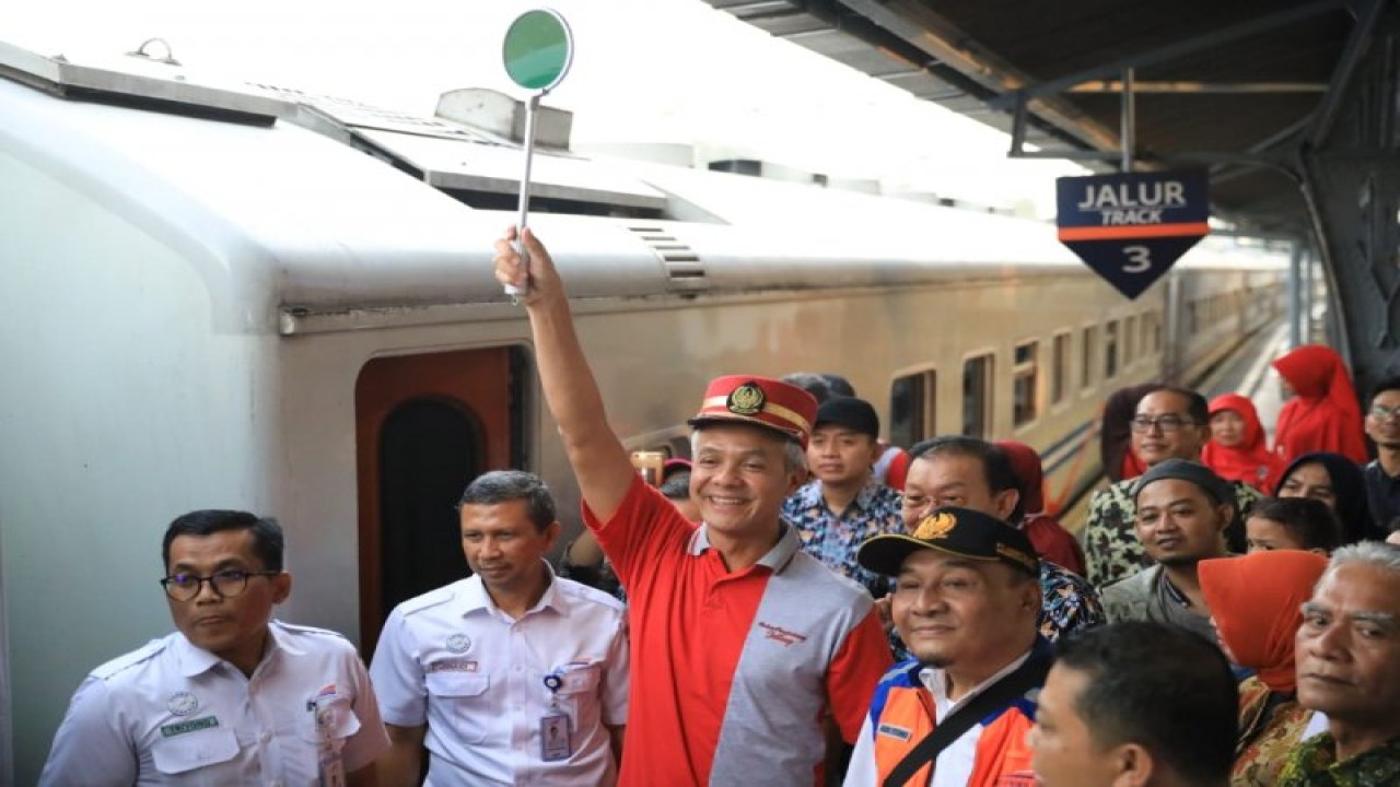 Ilustrasi: Gubernur Ganjar Pranowo mengangkat tongkat petugas Pengatur Perjalanan Kereta Api (PPKA) saat melepas mudik gratis warga Jawa Tengah dengan menggunakan kereta api di Stasiun Pasar Senen, Jakarta, Minggu (2/6). (Foto: Dok.Humas Pemprov Jateng)