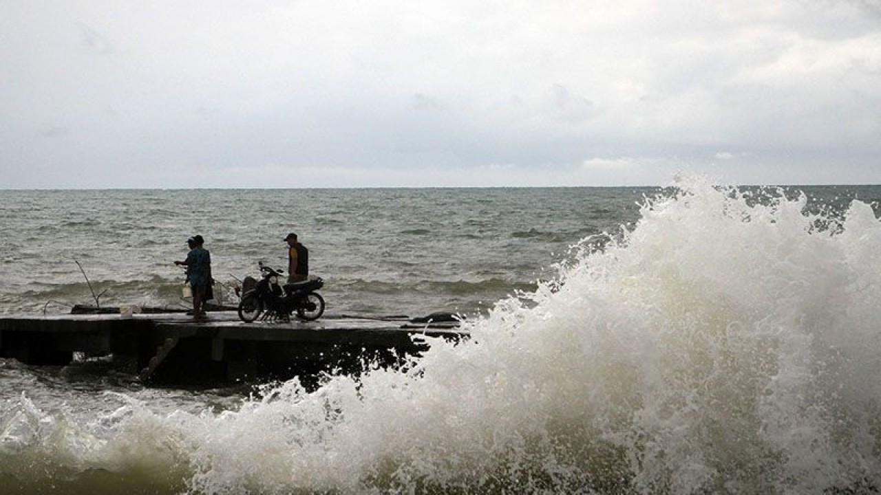 Arsip Foto - Warga melihat gelombang di dermaga Pangkalan Pendaratan Ikan Beba, Kabupaten Takalar, Sulawesi Selatan. (ANTARA/ARNAS PADDA)