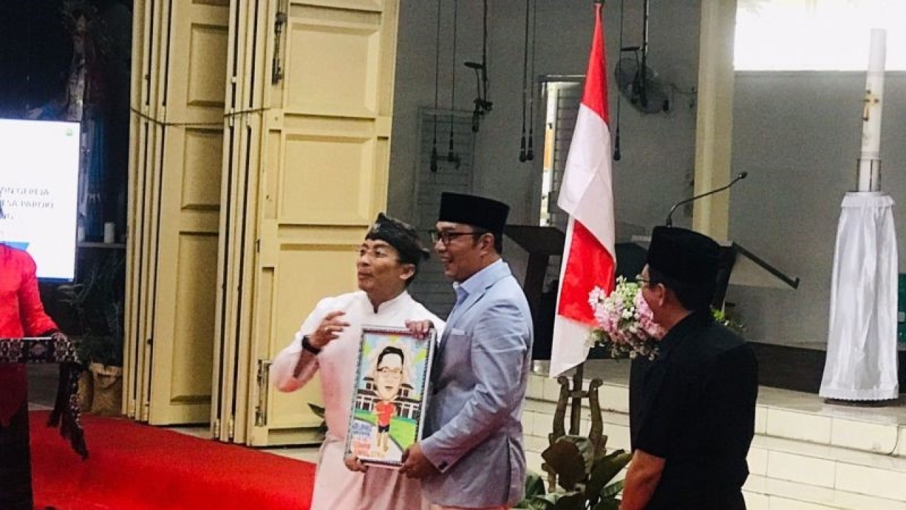 Gubernur Jawa Barat menerima cinderamata lukisan dari Kepala Pastor Teresa Cikarang Romo Antonius Suhardi Antara saat serah terima dokumen persetujuan bangunan gedung Gereja Paroki Ibu Teresa di Cikarang, Kabupaten Bekasi, Jawa Barat, Selasa (11/04/2023). ANTARA/Pradita Kurniawan Syah