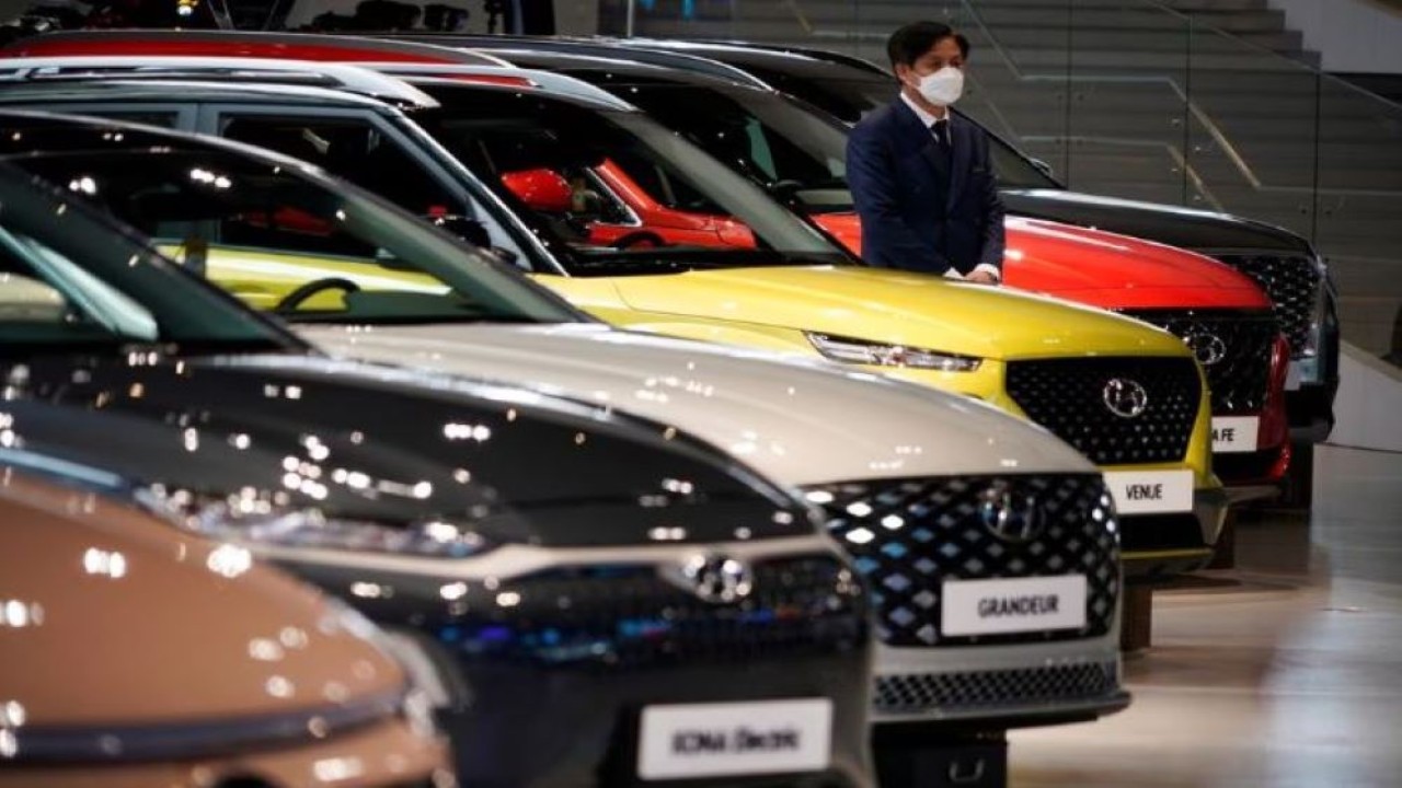 Seorang karyawan memakai masker untuk mencegah tertular penyakit virus corona (Covid-19) menunggu pelanggan di samping kendaraan Hyundai Motor di Hyundai Motor Studio di Goyang, Korea Selatan, 21 April 2020. (Kim Hong-Ji/Reuters)