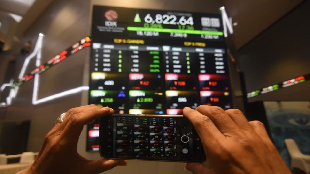 Pegawai memotret layar pergerakan saham di Bursa Efek Indonesia, Jakarta, Senin (3/4/2023). ANTARA FOTO/Indrianto Eko Suwarso/tom.