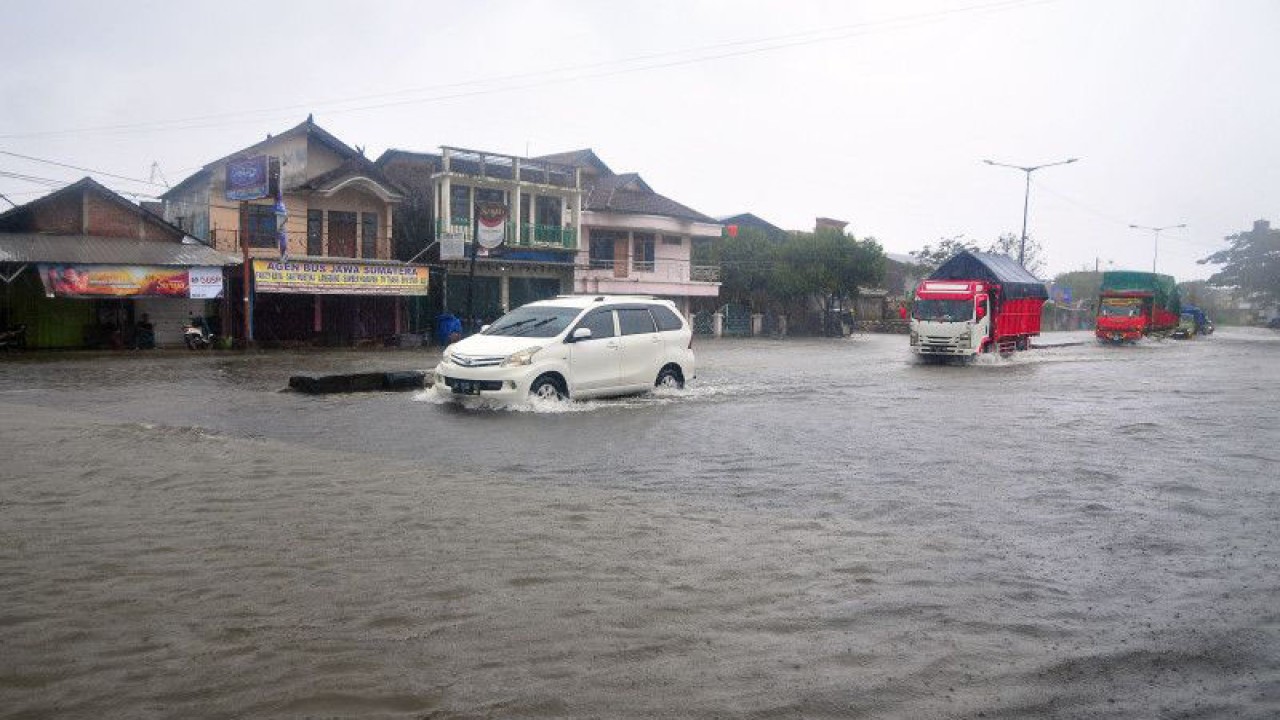 Arsip Foto. Kendaraan melaju di jalanan yang tergenang saat hujan mengguyur Jalur Pantura di Desa Jati Wetan, Kudus, Jawa Tengah, Kamis (2/3/2023). (ANTARA FOTO/YUSUF NUGROHO)