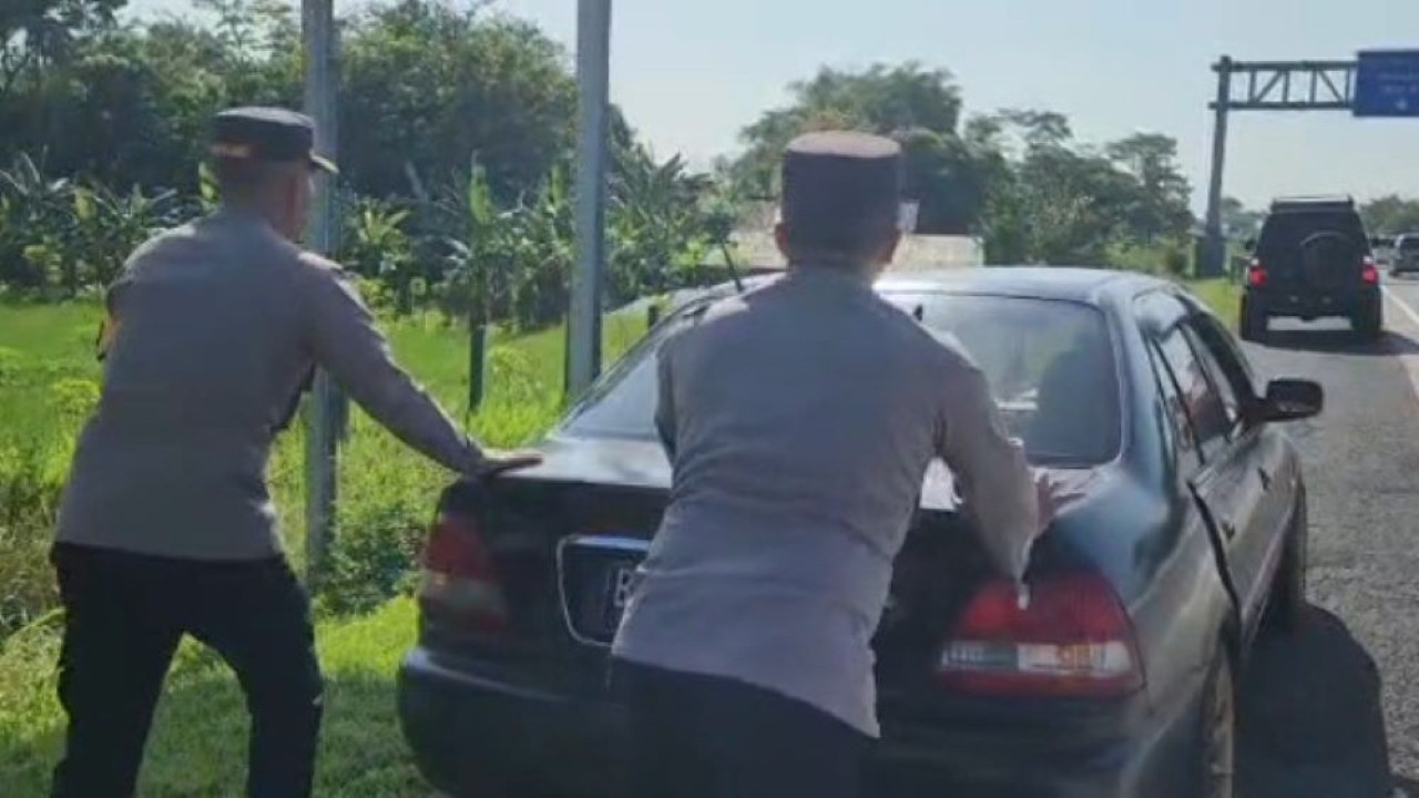Aksi Kapolres dan Wakapolres Boyolali mendorong mobil pemudik yang mogok di tol Semarang-Solo di daerah Boyolali. Kamis (20/4/2023). (Istimewa/boyolali.go.id)