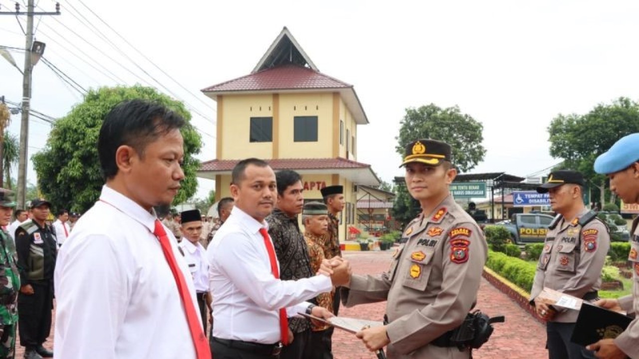 Kapolres Asahan AKBP Roman Smaradhana Elhaj (kanan) memberikan penghargaan kepada personel yang berprestasi . (ANTARA/HO-Humas Polres Asahan)