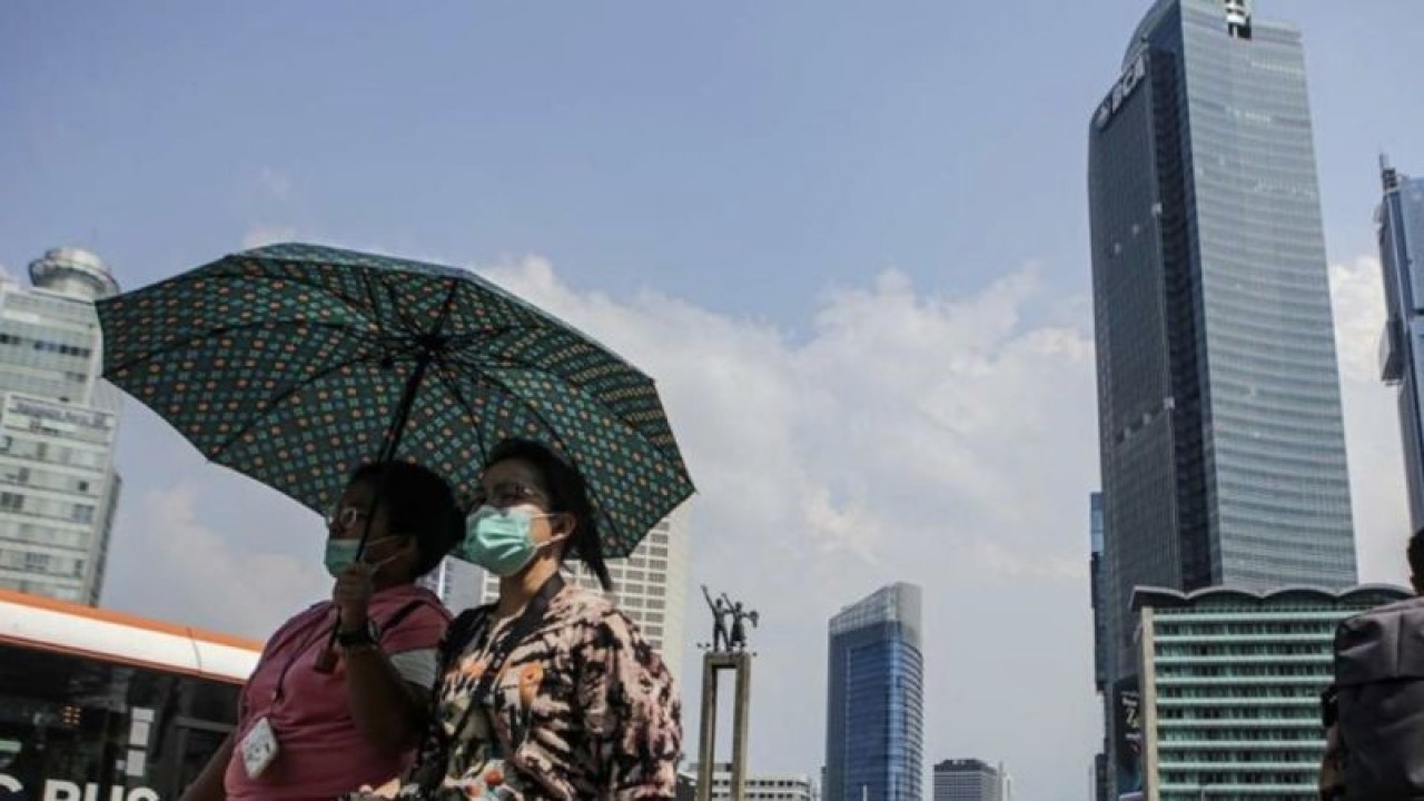 Warga berjalan di tengah cuaca terik di kawasan Bundaran HI, Jakarta, Senin (24/4/2023). Badan Meteorologi Klimatologi dan Geofisika (BMKG) menyampaikan dinamika atmosfer yang tidak biasa menjadi salah satu penyebab Indonesia mengalami suhu panas dalam beberapa hari terakhir. (ANTARA FOTO/Fauzan/nym).