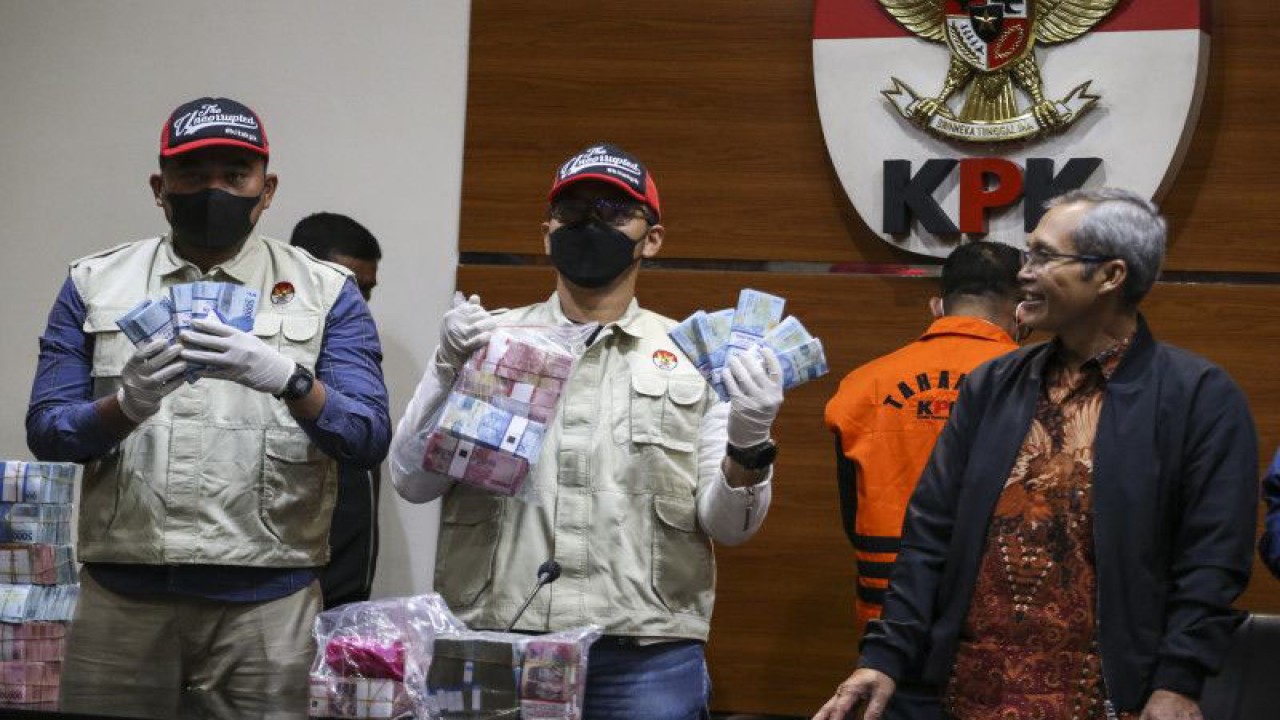 Petugas menunjukkan barang bukti uang tunai disaksikan Wakil Ketua KPK Alexander Marwata (kanan) saat konferensi pers terkait Operasi Tangkap Tangan Bupati Kepulauan Meranti Muhammad Adil di Gedung Merah Putih KPK, Jakarta, Jumat (7/4/2023). (ANTARA FOTO/Rivan Awal Lingga/hp)