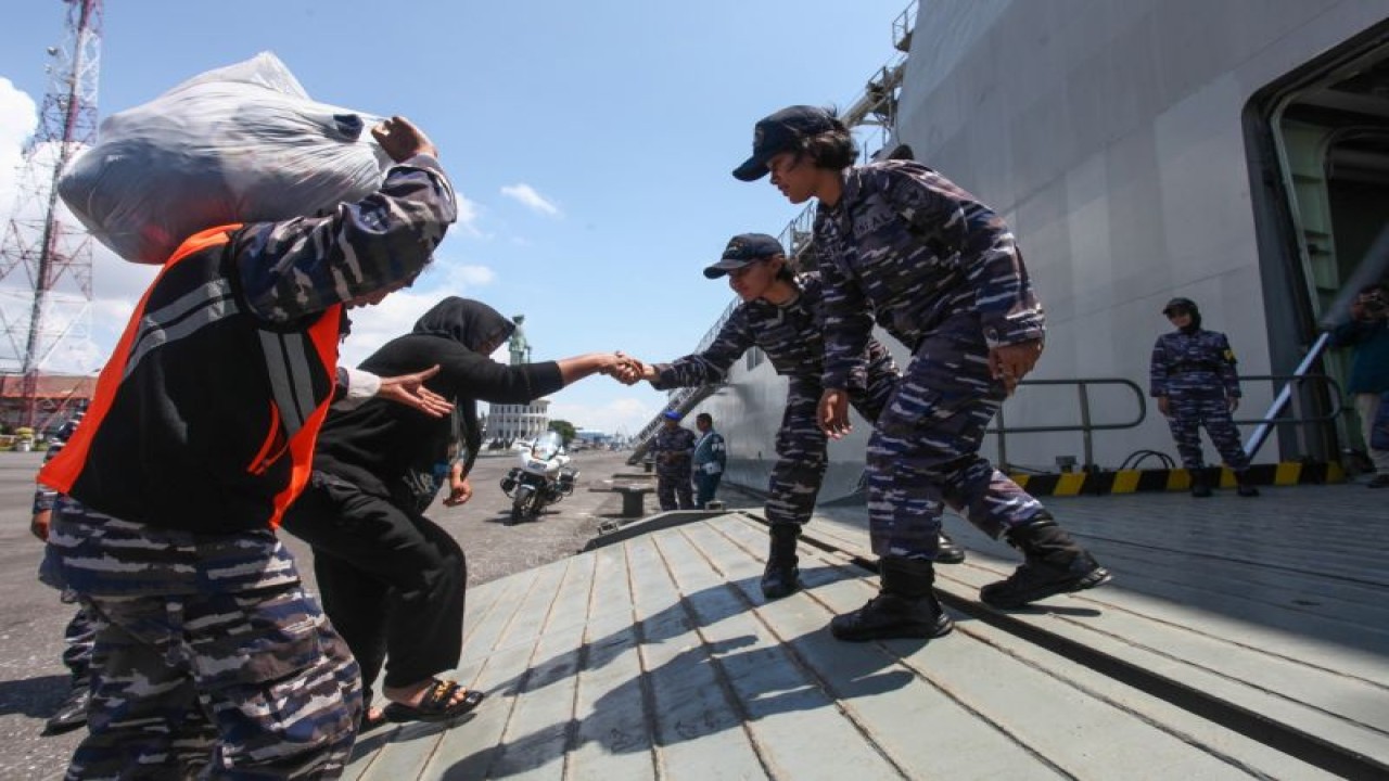 Prajurit TNI AL membantu pemudik masuk ke dalam KRI Banjarmasin-592 yang akan berangkat menuju Jakarta dari Dermaga Madura Koarmada II, Surabaya, Selasa (25/4/2023). (ANTARA/Didik Suhartono)