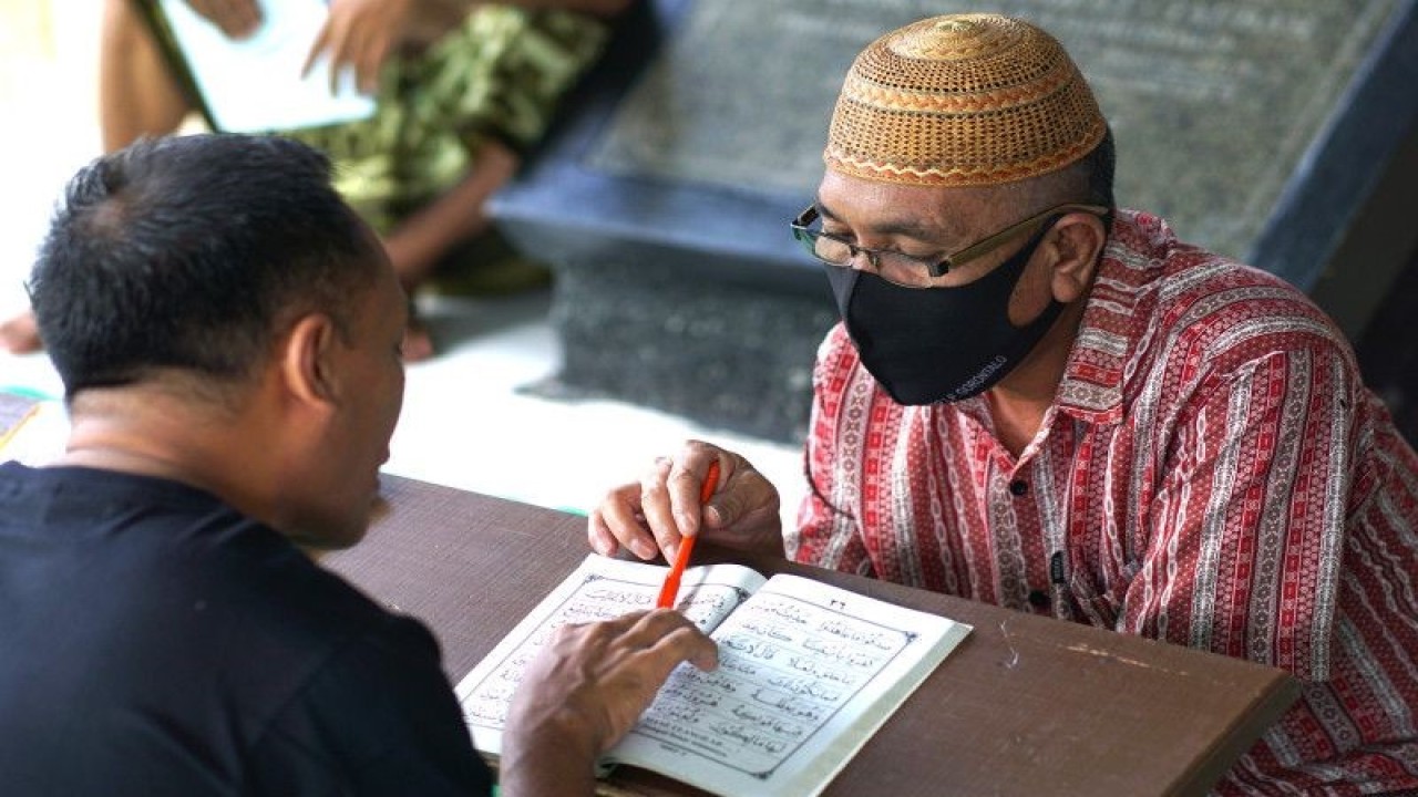 Seorang warga binaan pemasyarakatan belajar mengaji di pelataran Masjid At Taubah Lapas Kelas IIA Gorontalo, Senin (3/4/2023). ANTARA/Adiwinata Solihin