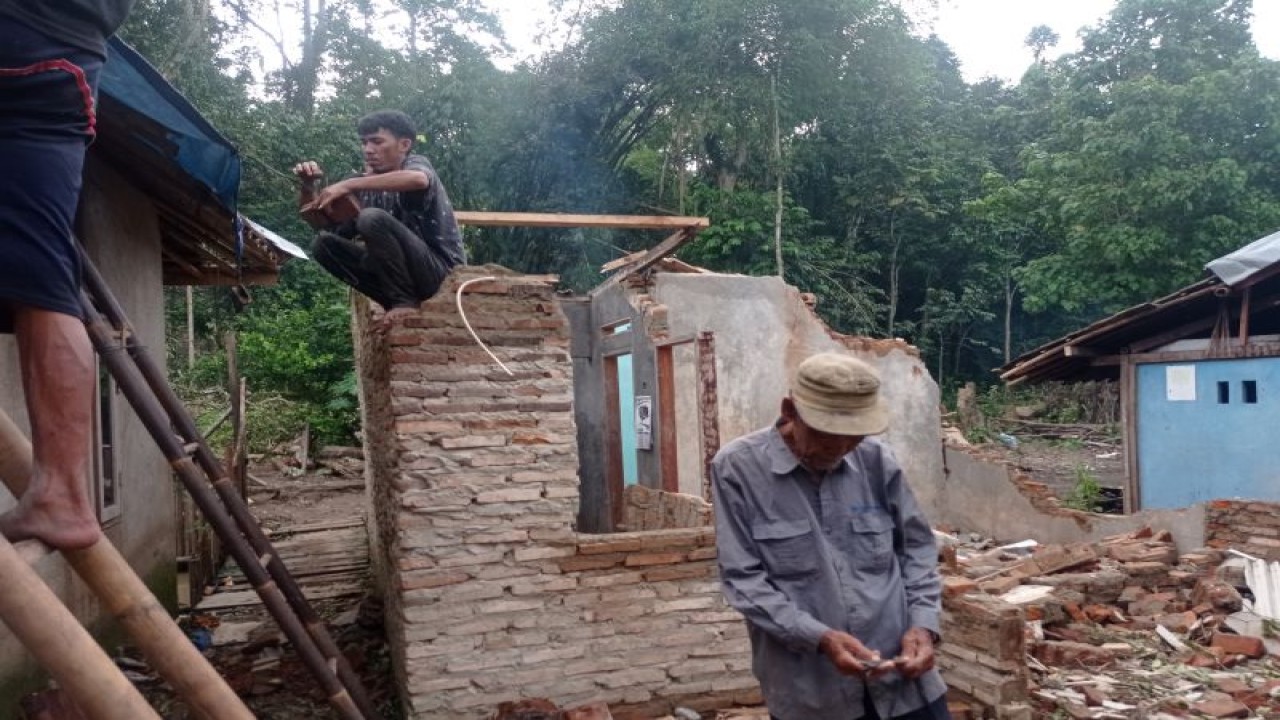 Sejumlah orang di dekat rumah di Kecamatan Kalanganyar, Kabupaten Lebak yang rusak berat diterjang angin kencang. ANTARA/Mansur