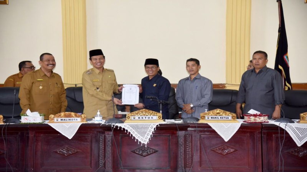 Wali Kota Pariaman Genius Umar (kiri) menyerahkan LKPJ Kepala Daerah atas Pelaksanaan Anggaran Pendapatan dan Belanja Daerah Pariaman Tahun Anggaran 2022 kepada Ketua DPRD Pariaman Harpen Agus Bulyandi (kanan) dalam rapat paripurna di Kota Pariaman, Provinsi Sumatera Barat, Senin (3/4/2023). (ANTARA/HO-DPRD Pariaman)
