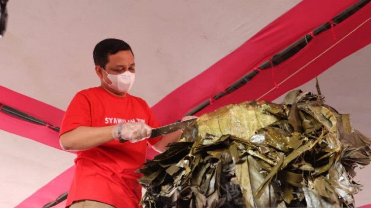 Wali Kota Pekalongan Afzan Arslan Djunaid melakukan pemotongan lopis raksasa untuk diberikan pada seorang tokoh masyarakat di Kelurahan Krapyak, Kota Pekalongan pada perayaan tradisi Syawalan 2022. (ANTARA/Dokmen Pribadi)