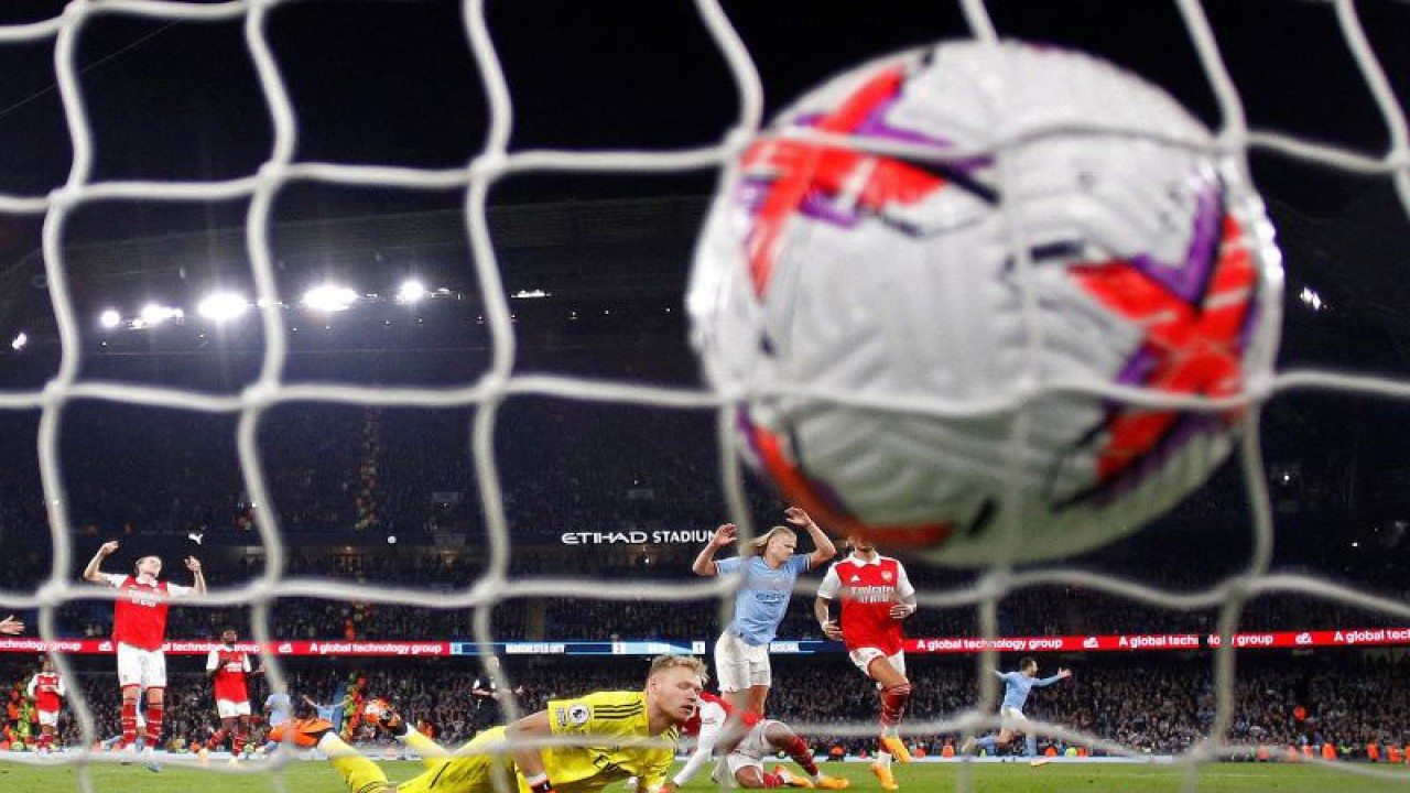 Pesepak bola Manchester City Erling Haaland mencetak gol ke gawang Arsenal yang dikawal Aaron Ramsdale dalam laga lanjutan Liga Inggris di Etihad Stadium, Manchester, Inggris, Rabu (26/4/2023). City menang dengan skor 4-1. ANTARA FOTO/REUTERS/Phil Noble/foc.