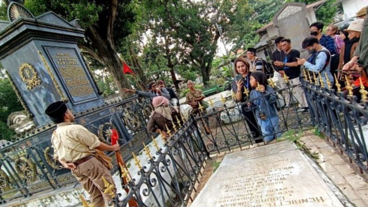 Sejumlah peserta mendengarkan pemandu menjelaskan kisah luburan Pierre Jean Baptiste de Perez di Makam Belanda Peneleh, Surabaya, Minggu (9/4/2023). (ANTARA/Naufal Ammar Imaduddin  )