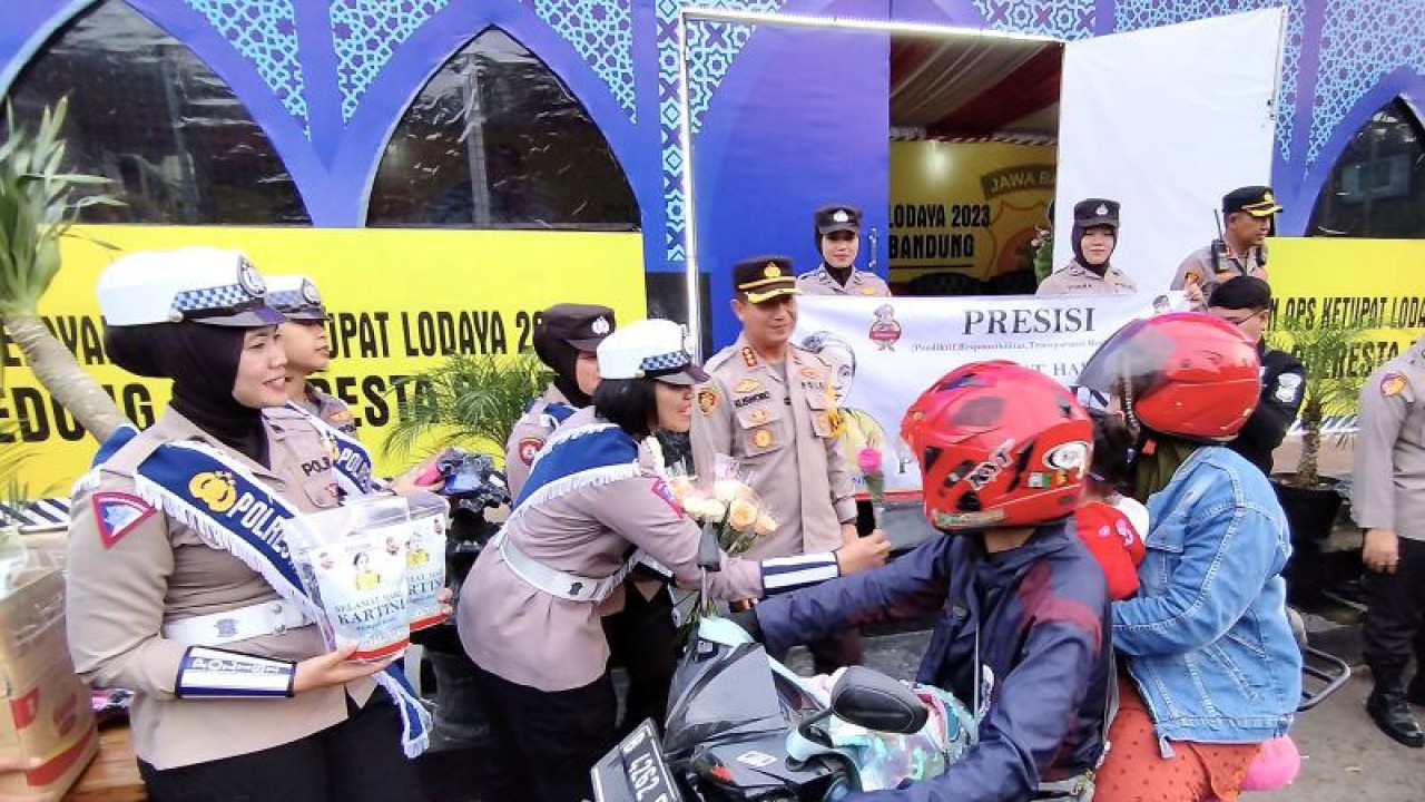 Polwan memberikan bunga kepada pemudik di kawasan Nagreg, Kabupaten Bandung, Jawa Barat. (ANTARA/Bagus Ahmad Rizaldi)