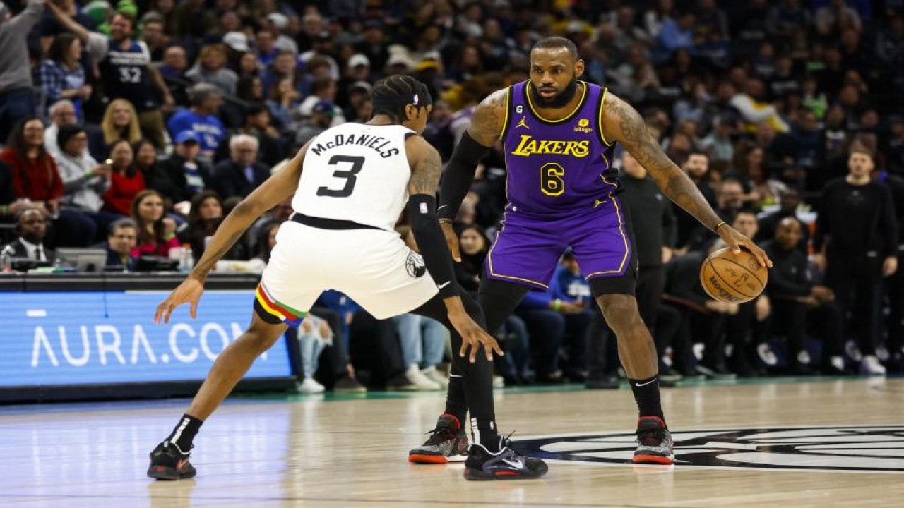 Pebasket Los Angeles Lakers LeBron James (kanan) melakukan dribel dihalangi pebasket Minnesota Timberwolves Jaden McDaniels (kiri) saat quarter pertama pertandingan NBA kedua tim di Target Center Minneapolis, Minnesota, Jumat (31/3/2023) (Photo by David Berding / GETTY IMAGES NORTH AMERICA / Getty Images via AFP) (Getty Images via AFP/DAVID BERDING)