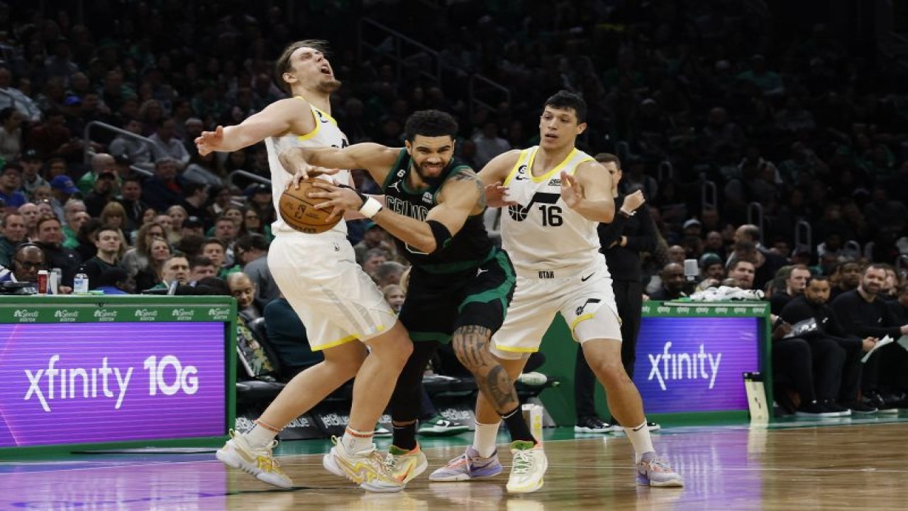 Pebasket Boston Celtics Jayson Tatum (tengah) berupaya lepas dari penjagaan ketat dua pebasket Utah Jazz Simone Fontecchio (kanan) dan Kelly Olynyk (kiri) saat pertandingan NBA kedua tim di TD Garden, Boston, Massachusetts, Jumat (31/3/2023) (Photo By Winslow Townson/Getty Images) (Photo by Winslow Townson / GETTY IMAGES NORTH AMERICA / Getty Images via AFP) (Getty Images via AFP/WINSLOW TOWNSON)