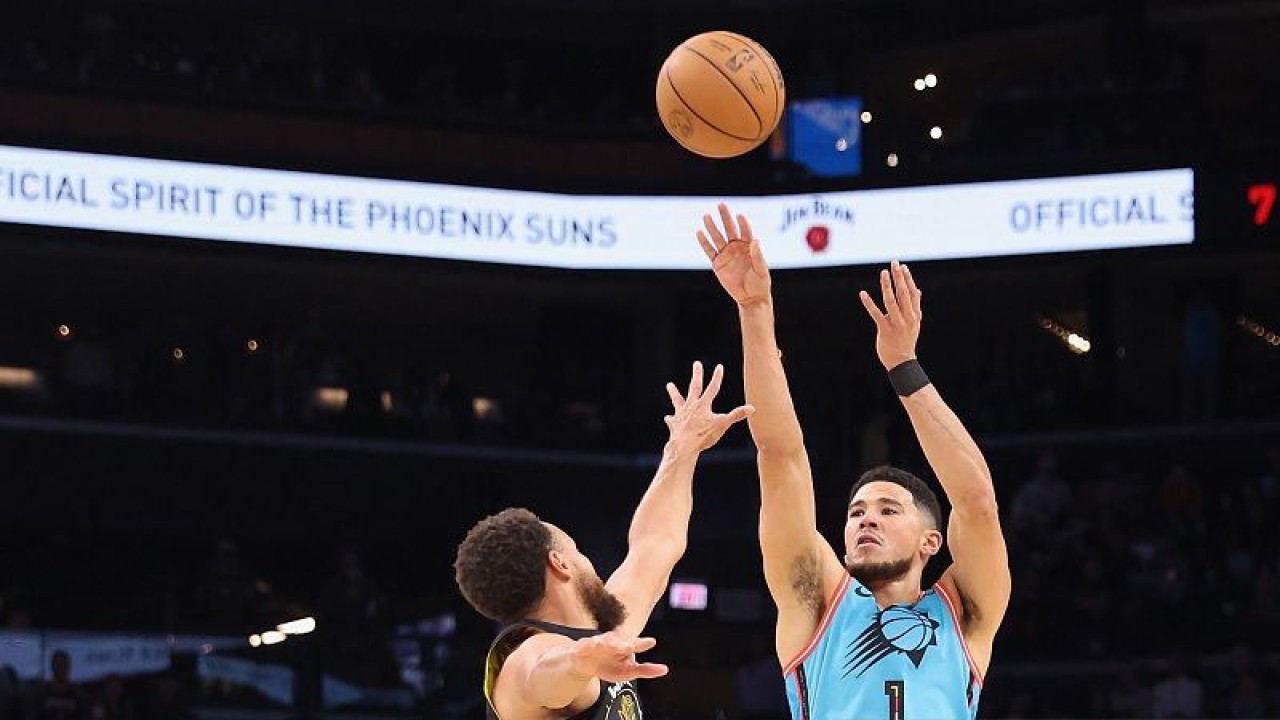 Foto arsip - Bintang Phoenix Suns Devin Booker (kanan) melepaskan tripoin di hadapan bintang Golden State Warriors Stephen Curry dalam lanjutan NBA di Footprint Center, Arizona, Amerika Serikat, Rabu (16/11/2022) waktu setempat. (ANTARA/AFP/GETTY IMAGES/Christian Petersen)