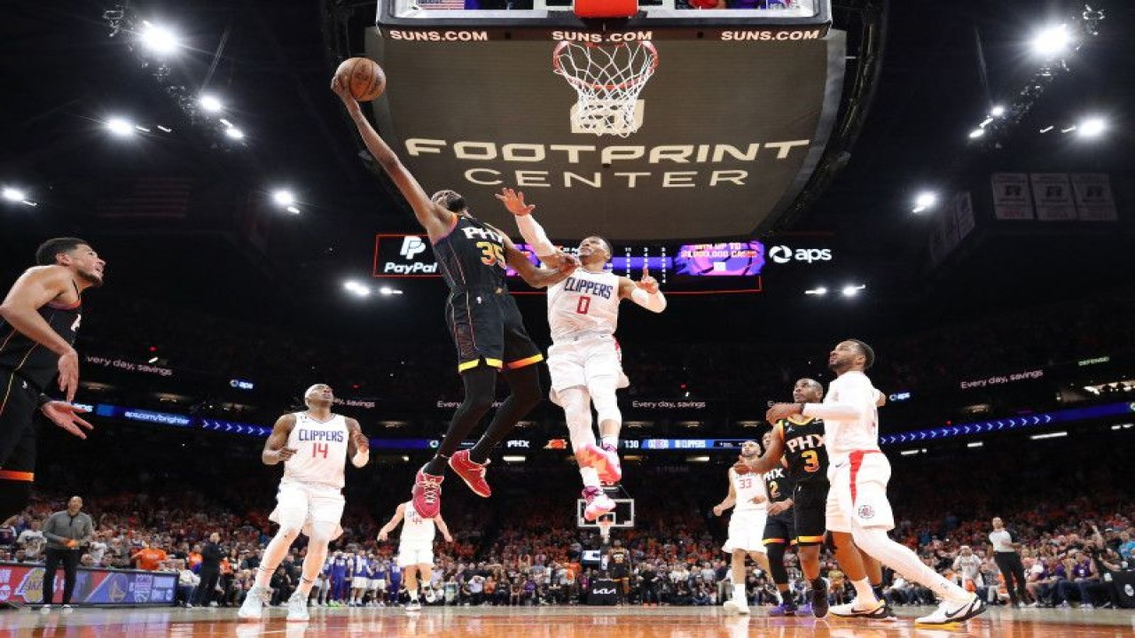 Pebasket Phoenix Suns Kevin Durant #35 berupaya memasukkan bola dan dihalangi pebasket LA Clippers Russell Westbrook saat kuarter keempat pertandingan putaran pertama playoff Wilayah Barat NBA di Footprint Center, Phoenix, Arizona, Selasa (25/4/2023) waktu setempat. (Getty Images via AFP/CHRISTIAN PETERSEN)