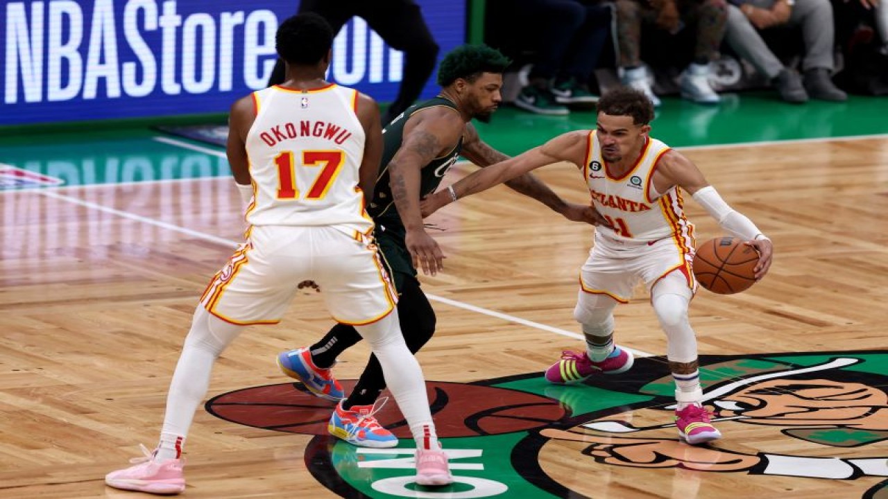 Pebasket Atlanta Hawks Trae Young (kanan) melakukan dribel dan dibayangi pebasket Boston Celtics Marcus Smart (tengah) saat kuarter keempat putaran pertama playoff Wilayah Timur di TD Garden, Boston, Massachusetts, Selasa (25/4/2023) (Getty Images via AFP/MADDIE MEYER)