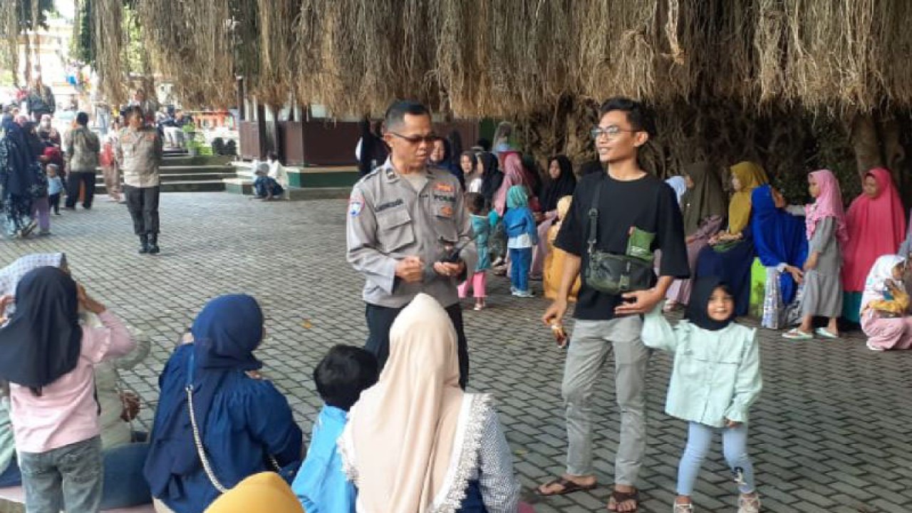 Personel kepolisian berkomunikasi dengan salah seorang peziarah di Makam Loang Baloq, Mataram, NTB, Rabu (26/4/2023). ANTARA/HO-Polresta Mataram