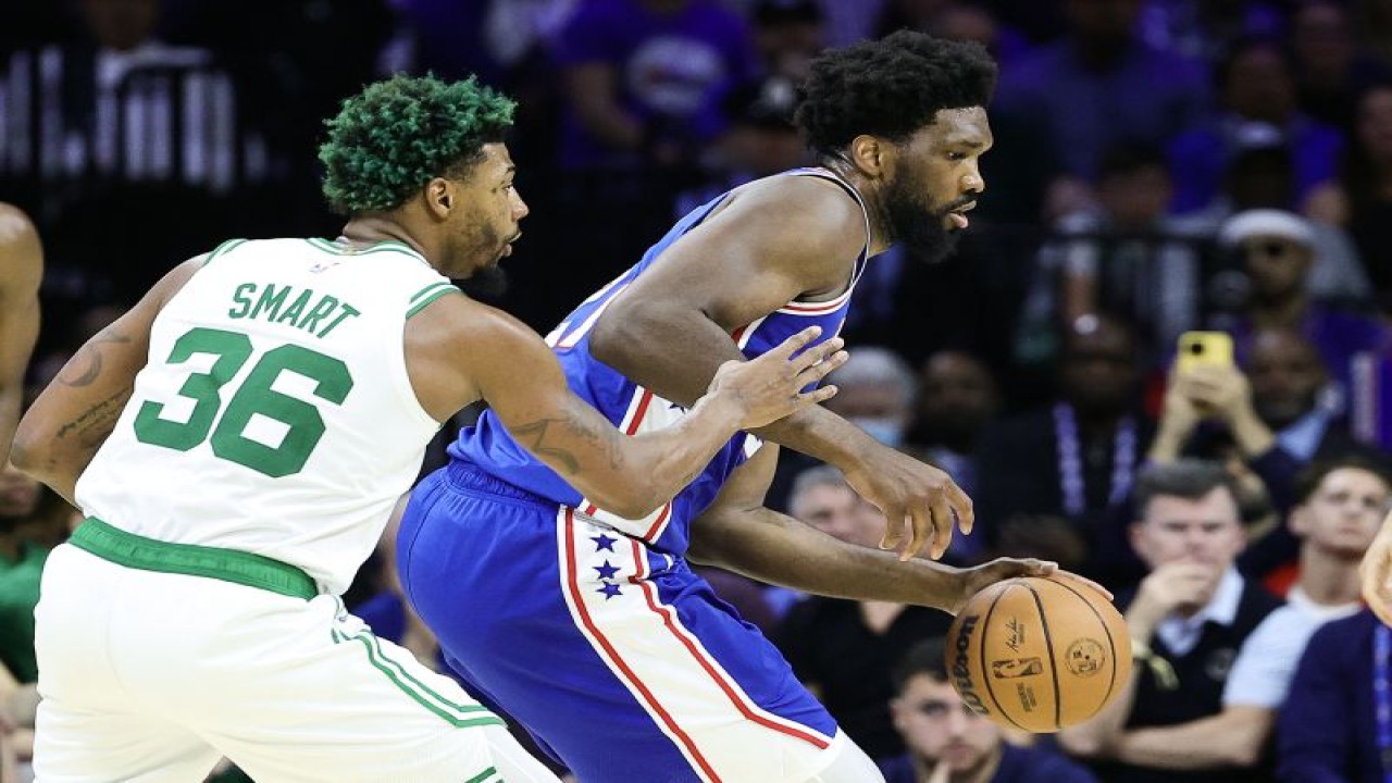 Pebasket Philadelphia 76ers Joel Embiid (kanan) mendribel bola dibayangi pebasket Boston Celtics Marcus Smart (kiri) saat luarter keempat pertandingan NBA kedua tim di Wells Fargo Center, Philadelphia, Selasa (4/4/2023) (Getty Images via AFP/TIM NWACHUKWU)