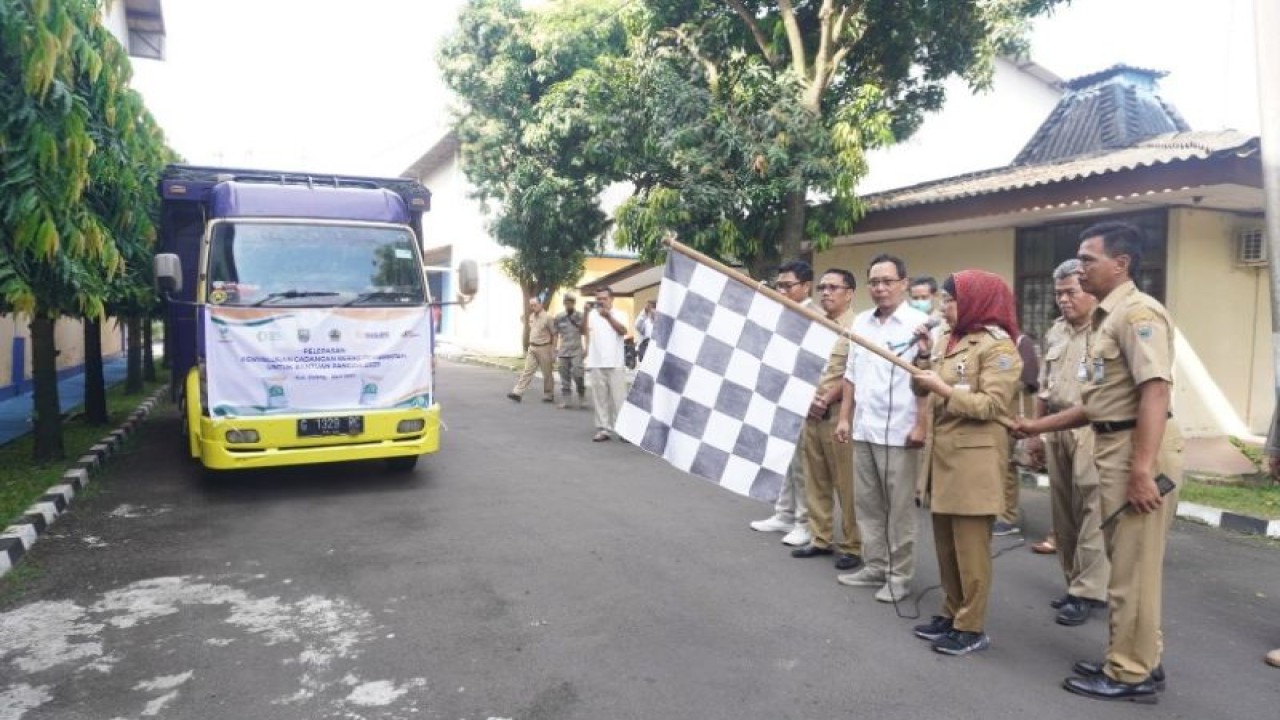 Penjabat BupatI Batang Lani Dwi Rejeki mengibarkan bendera tanda penyaluran bantuan beras cadangan pangan pemerintah daerah di Batang, Selasa (11/4/2023). (ANTARA/HO-Humas Batang)