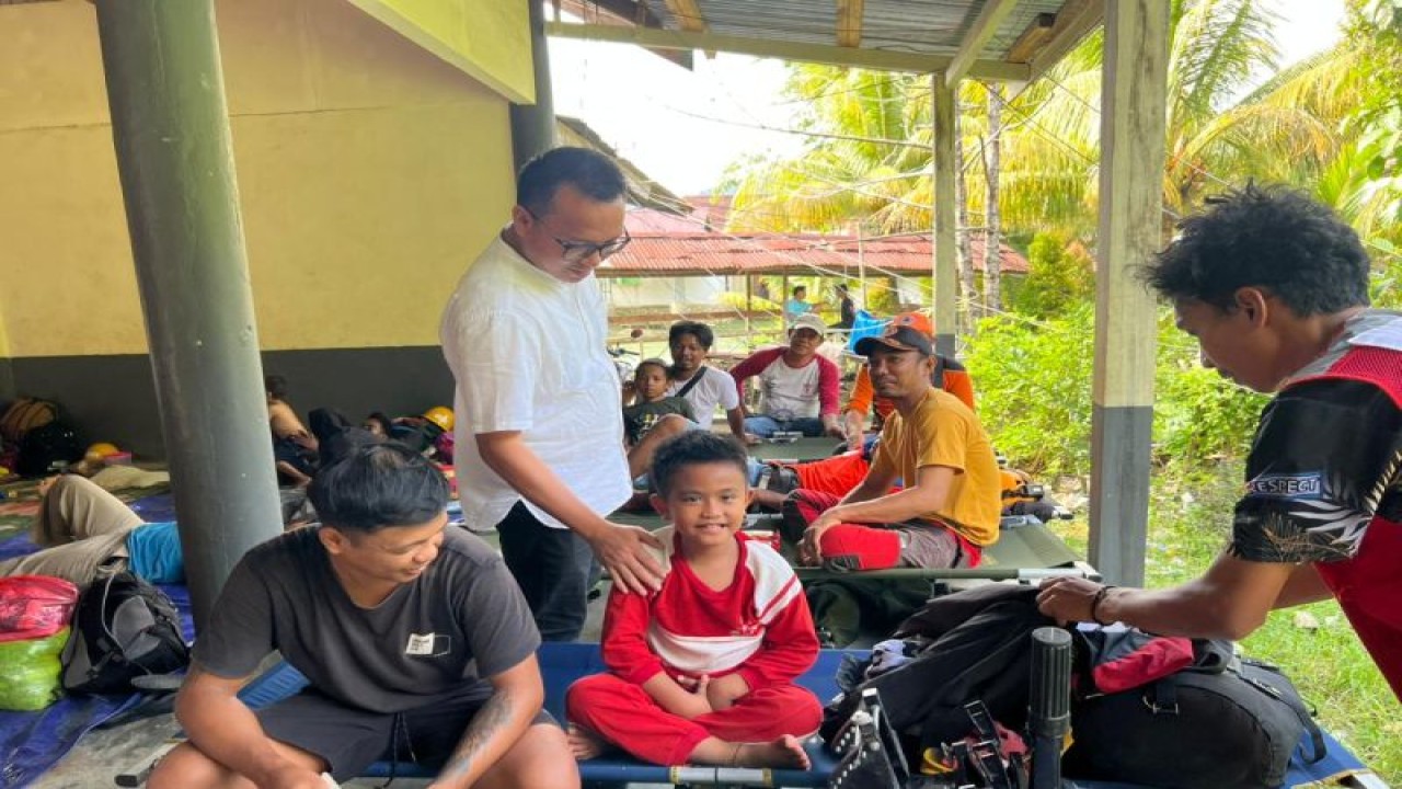 Bupati Morowali Utara, Sulteng, Delis J Hehi (baju putih) menyapa seorang anak korban banjir di posko pengungsian, Senin (10/4/2023). FOTO ANTARA/HO-Porkopim Pemkab Morut
