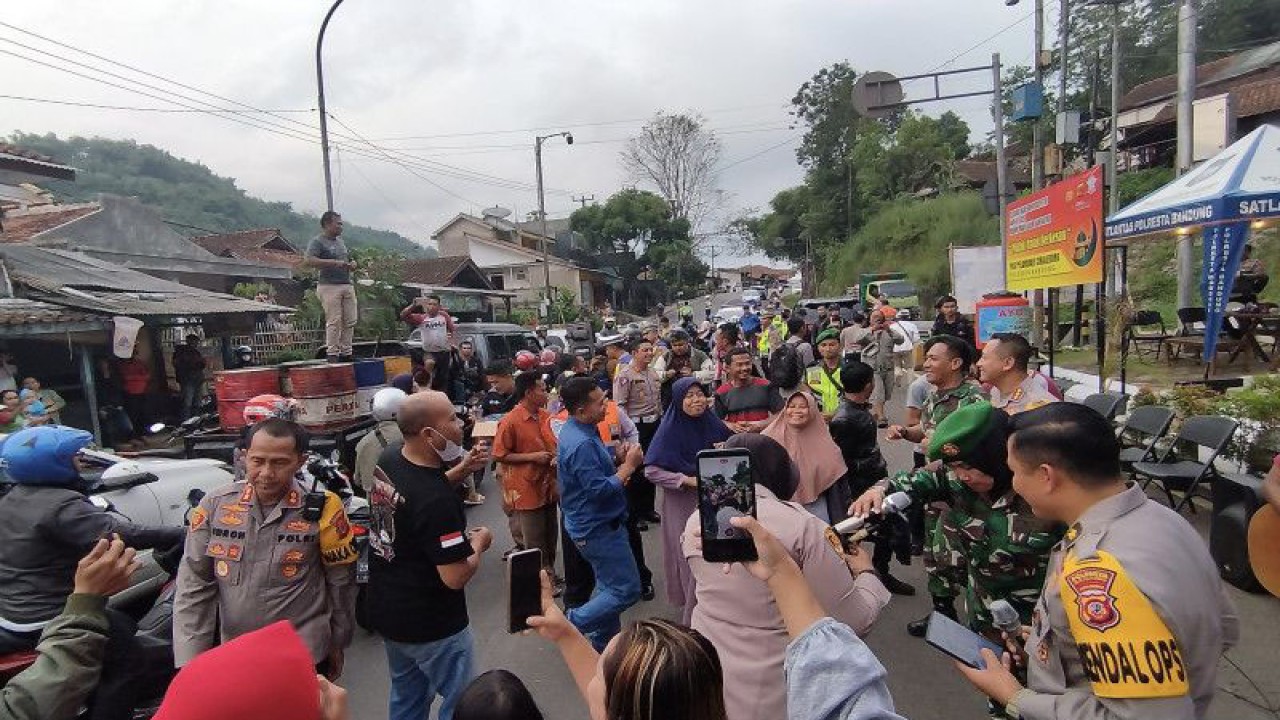 Pemudik bersama polisi dan TNI berjoget saat adanya penutupan sementara di Jalur Nagreg, Kabupaten Bandung, Jawa Barat, Sabtu (29/4/2023). ANTARA/Bagus Ahmad Rizaldi.