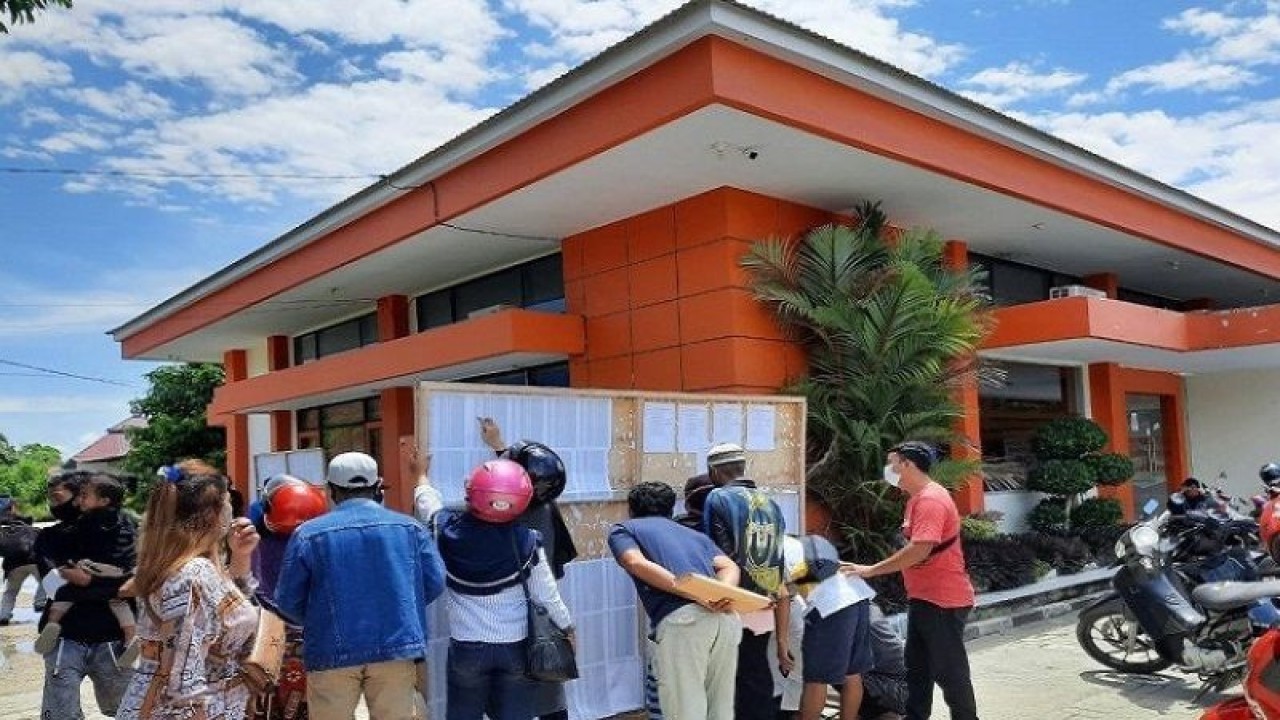Warga penerima bansos di Kota Kendari, saat antri melihat nama-nama yang di tempel di kantor Pos Cabang Kendari, Sultra. ANTARA/Azis Senong