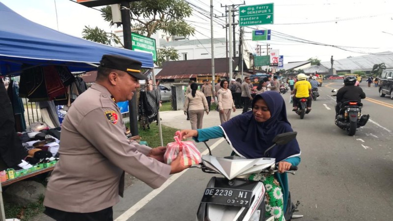 Personel Bidhumas Polda Maluku saat membagi takjil gratis untuk warga Ambon, Senin(10/4/2023). ANTARA/HO-Polda Maluku