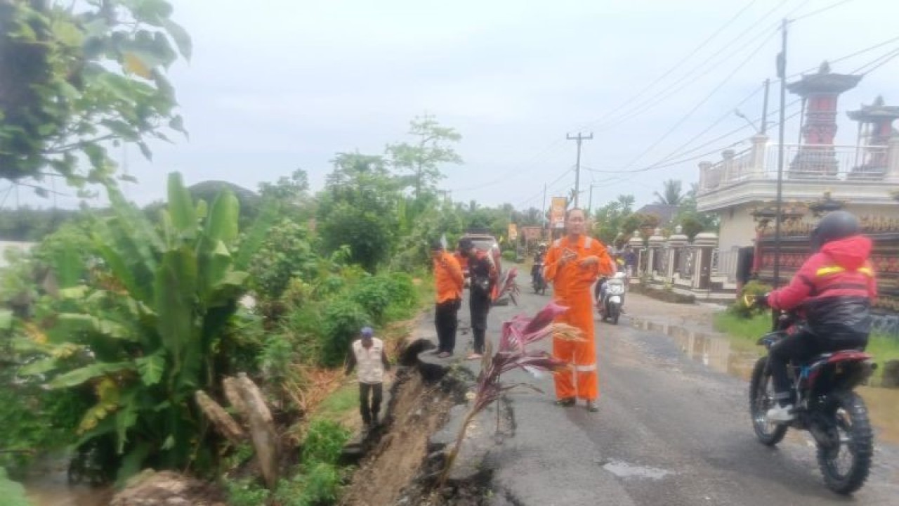 Personel BPBD OKU Timur memasang rambu peringatan bahaya longsor, Selasa. (ANTARA/Edo Purmana/23)