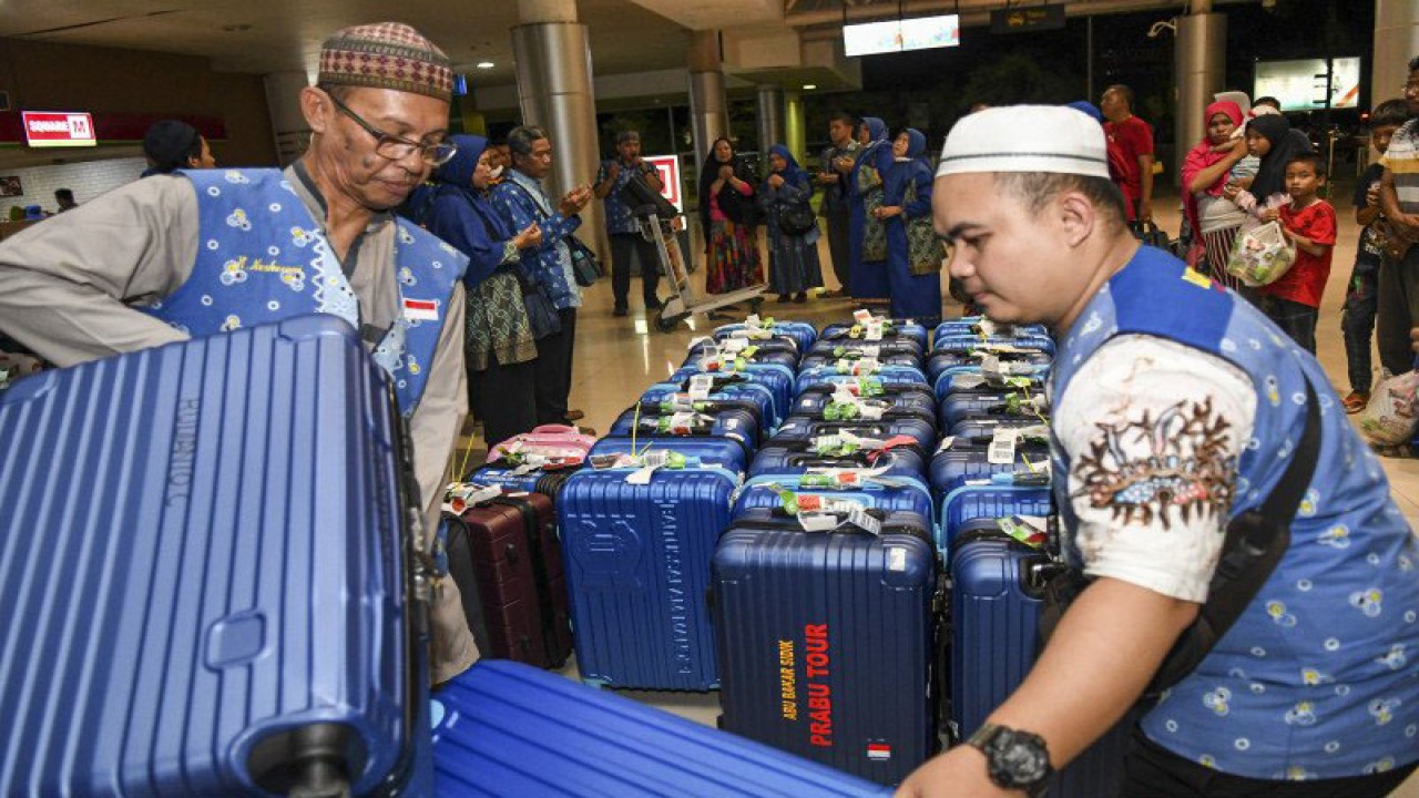 Ilustrasi - Petugas menurunkan koper calon jamaah umrah yang batal berangkat ke Jeddah lewat Singapura saat tiba di Bandara International Sultan Mahmud Badaruddin (SMB) II Palembang, Sumatera Selatan, Jumat (28/2/2020). ANTARA FOTO/Nova Wahyudi/nz