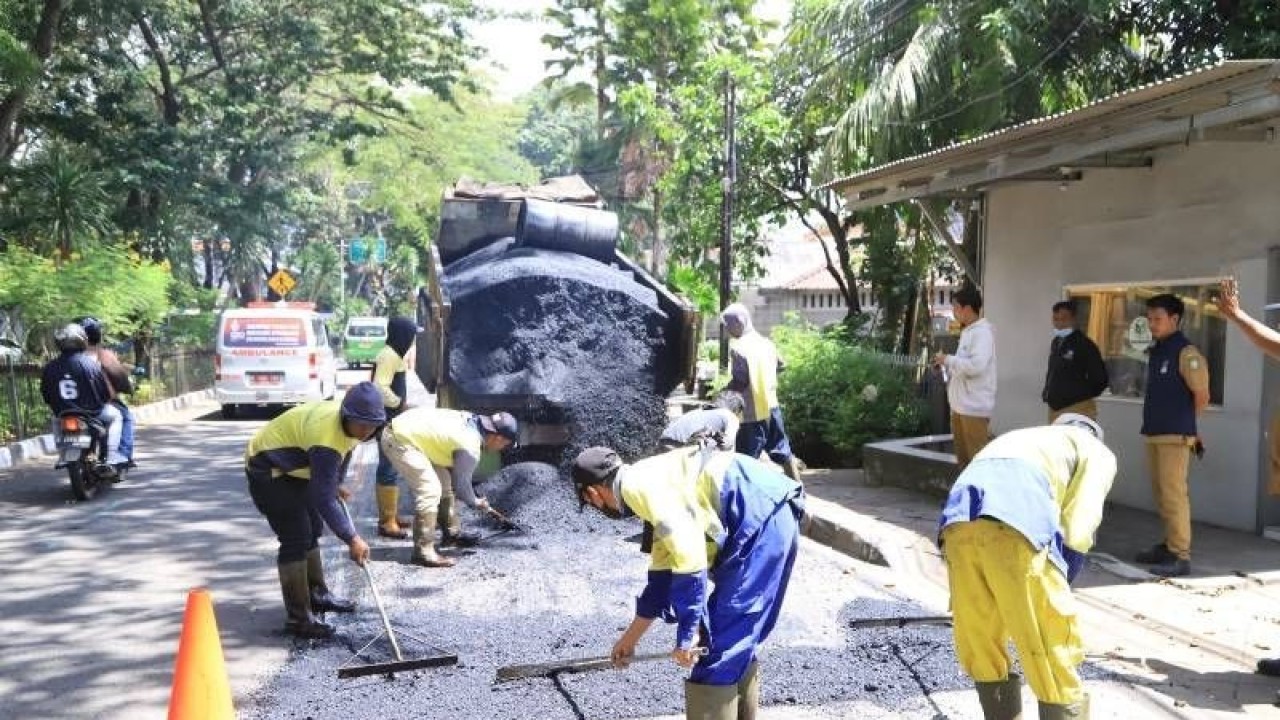Petugas DPUPR Kota Tangerang sedang melakukan perapihan jalan yang merupakan jalur mudik