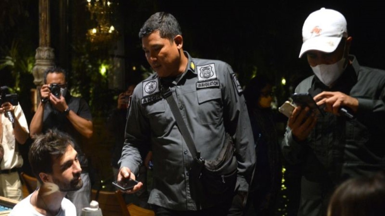 Petugas imigrasi memeriksa dokumen keimigrasian yang dimiliki warga negara asing (WNA) di kawasan Ubud, Gianyar, Bali, Sabtu (15/4/2023). ANTARA/Naufal Fikri Yusuf