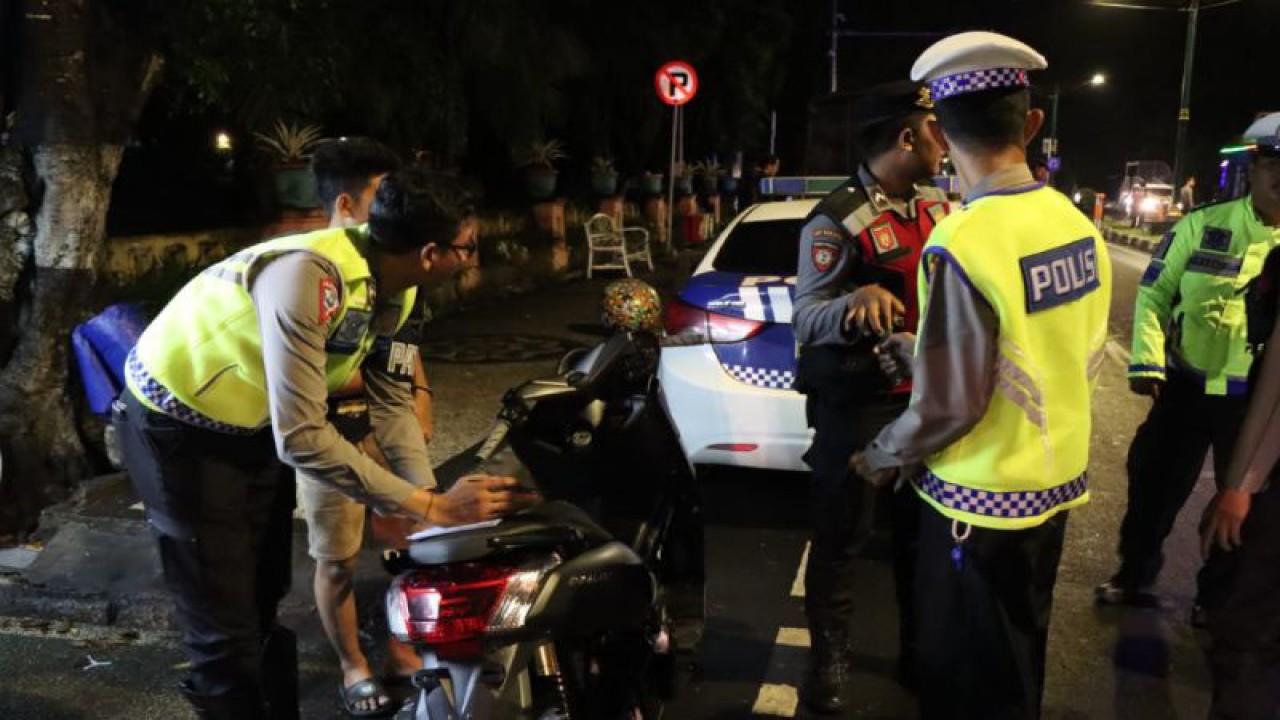 Petugas kepolisian membuatkan surat tilang untuk pengendara yang menggunakan kendaraan knalpot bising di Jalan Udayana, Mataram, Rabu (12/4/2023). (ANTARA/HO-Polresta Mataram)