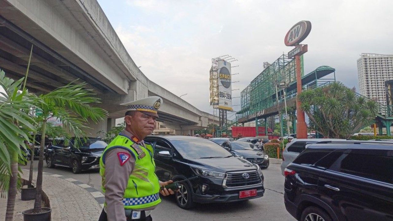 Kepala Unit Pengaturan Penjagaan Pengawalan Patroli (Turjawali) Polres Metro Bekasi Kota AKP Ganda Siburian saat mengatur lalu lintas di ruas Jalan Raya Kalimalang, Bekasi, Sabtu (15/4/2023). (ANTARA/Siti Nurhaliza)