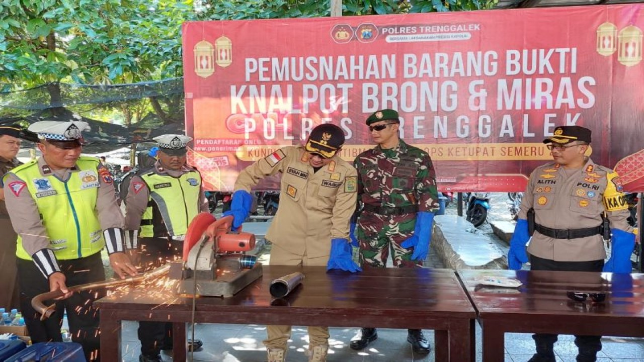 Petugas saat menggergaji knalpot brong hasil balap liar di Mapolres Trenggalek, Senin (17/4/2023) (ANTARA/HO - Humas Polres Trenggalek)