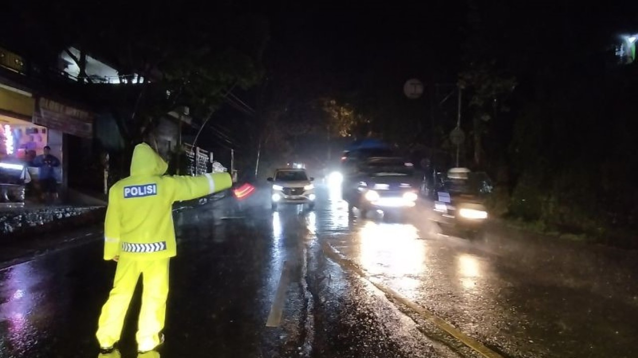 Polisi mengatur lalu lintas saat terjadi hujan di Jalur Nagreg, Kabupaten Bandung, Jawa Barat. (ANTARA/Bagus Ahmad Rizaldi)