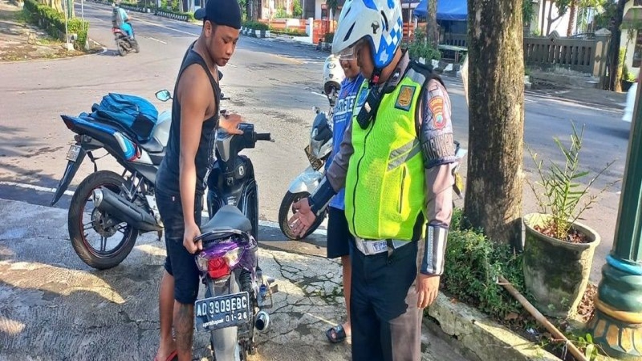 Seorang petugas saat menindak seorang pengendara sepeda motor yang tidak menggunakan helm di Jalan Pandanaran Boyolali, Selasa (4/4/2023). ANTARA/Bambang Dwi Marwoto.