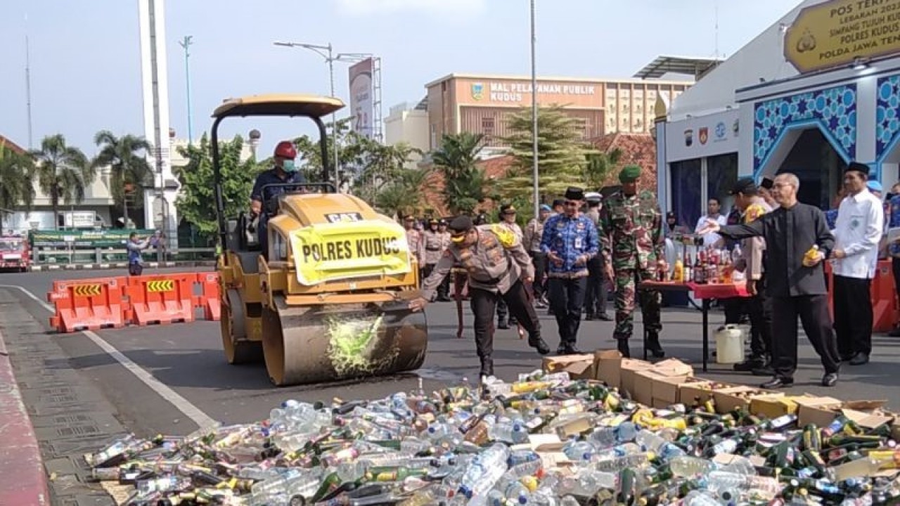 Kapolres Kudus AKBP Dydit Dwi Susanto memecahkan botol minuman keras ke kereta penghalus jalan di Alun-alun Kudus, Jawa Tengah, Senin (17/4/2023). ANTARA/Akhmad Nazaruddin Lathif