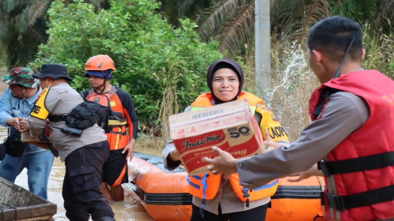 Kapolres Tebo AKBP Fitria Mega dan tim gabungan membantu pelaksanaan evakuasi dan penyaluran bahan makanan dan perlengkapan lainnya untuk korban banjir di Tebo, Jambi, Selasa (25/4/2023). (ANTARA/HO-Polres Tebo).