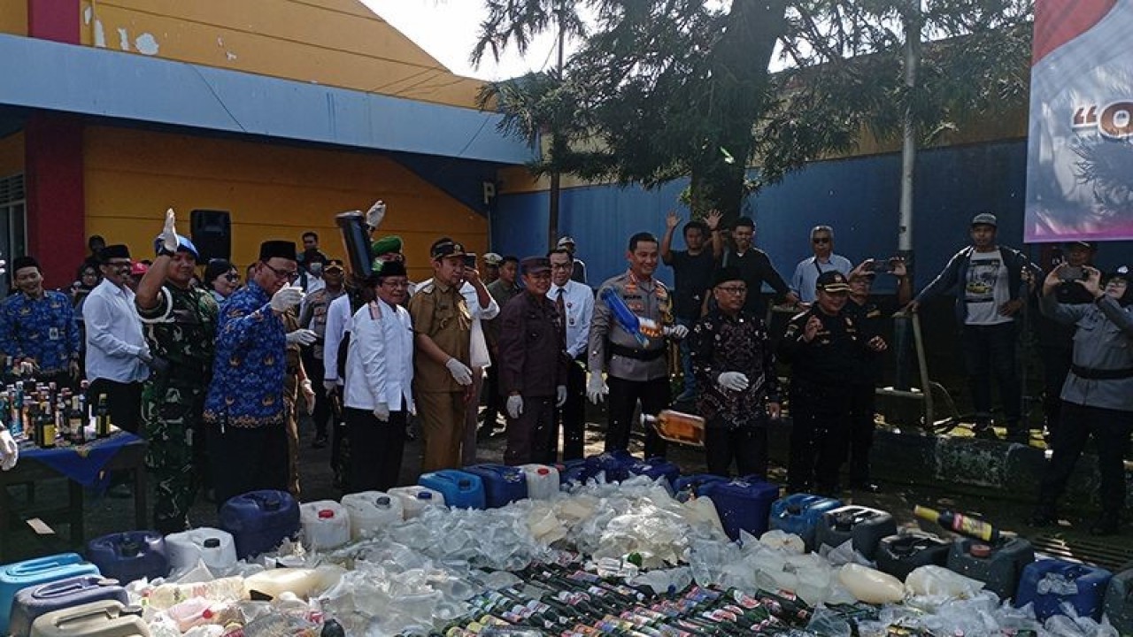 Bupati Banyumas Achmad Husein bersama anggota Forkompimda Banyumas melempar botol minuman beralkohol ke arah tumpukan minuman sejenis yang akan dimusnahkan dengan cara digilas menggunakan stoomwalls di area parkir Gelanggang Olahraga Satria, Purwokerto, Kabupaten Banyumas, Senin (17/4/2023). ANTARA/Sumarwoto