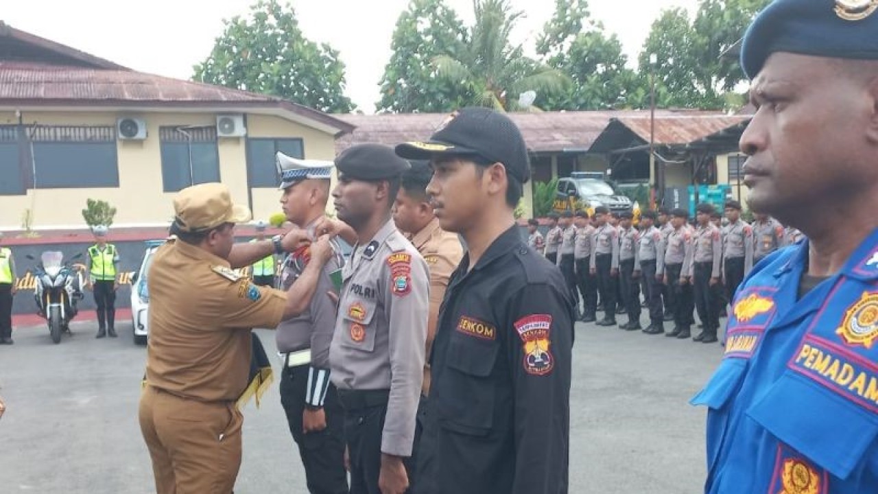 Bupati Manokwari Hermus Indou menyematkan pita personel pengamanan pada apel gelar pasukan Operasi Ketupat Mansinam 2023 di Markas Polresta Manokwari, Senin (17/4/2023). ANTARA/Fransiskus Salu Weking